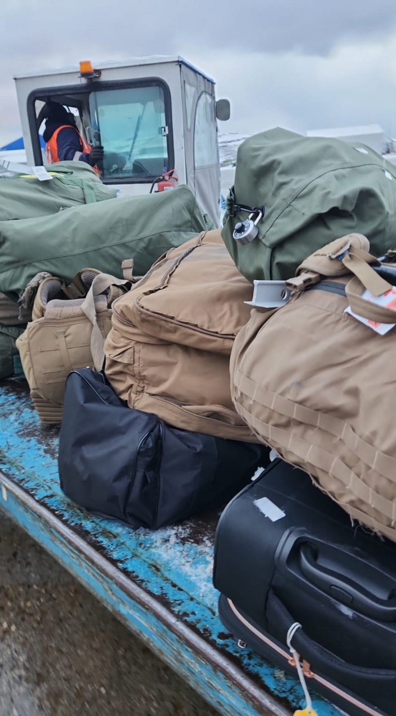 Equipaje con recintos y rótulos de carga aérea militar son bajados en el aeropuerto Malvinas Argentinas de Ushuaia. Los bultos exhiben etiquetas reforzadas de embarque y despacho en tránsito, coincidentes con el movimiento de delegaciones técnicas extranjeras en enlaces de transporte combinado. Foto: Agenda Malvinas.